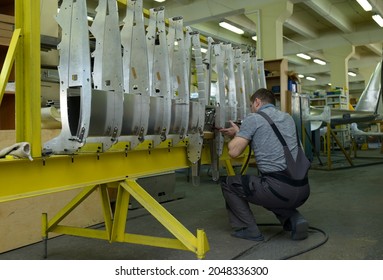 Worker Working With A Pneumatic Drill Assembling A Fuselage Of Light Plane At The Assembly Shop. February 11, 2020. Kyiv, Ukraine