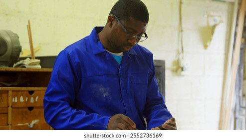 Worker working at table in foundry workshop. Worker using calculator - Powered by Shutterstock