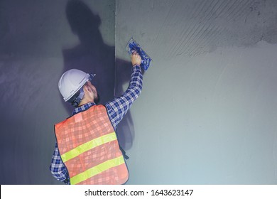 Worker Working With Wall Plastering Tools At Building Site.