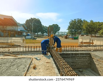 Worker works at construction sites. Using steel wire for securing steel bars with wire rod for reinforcement of concrete or cement