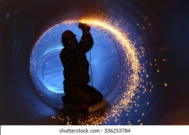 A worker works inside a pipe on a pipeline construction