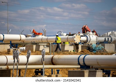 Worker works on a construction site of an interconnected natural gas transmission pipeline. Highly integrated network. Connection point between the transmission company and the receiving party. - Shutterstock ID 2141042341