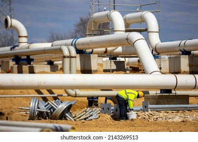Worker works on a construction site of an interconnected natural gas transmission pipeline. Highly integrated network. Connection point between the transmission company and the receiving party. - Shutterstock ID 2143269513