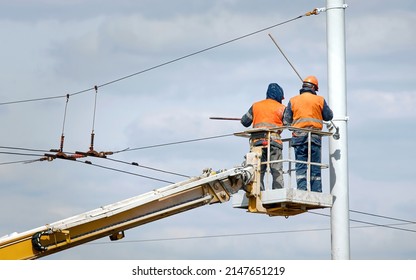 Workers In Aerial Platform Paint Street Light Pole At Height. Man In Cradle Painting Lamppost With Paint Brush. Cherry Picker With Worker At Height, Risky Job. Paint And Renovate Street Lightning Pole