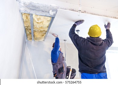 Workers Assemble A Suspended Ceiling With Drywall