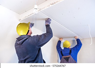 Workers Assemble A Suspended Ceiling With Drywall