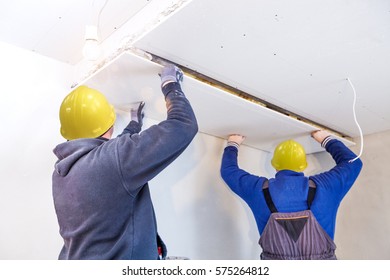 Workers Assemble A Suspended Ceiling With Drywall