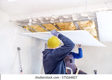 Workers Assemble A Suspended Ceiling With Drywall