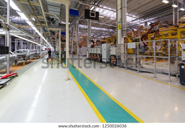 Workers assemble a vehicle body. process of welding\
cars. Modern Assembly of cars at the plant. automated build process\
of the car body