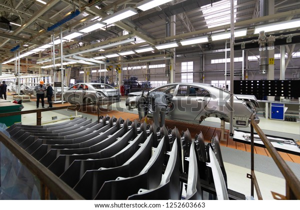 Workers assemble a vehicle body. process of welding
cars. Modern Assembly of cars at the plant. automated build process
of the car body