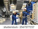 workers assembling and constructing gas turbines in a modern industrial factory