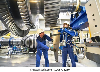 Workers Assembling And Constructing Gas Turbines In A Modern Industrial Factory