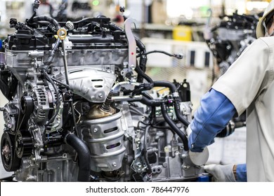 Workers are assembling engines in factories, which are at the heart of the car. (Automotive industry)