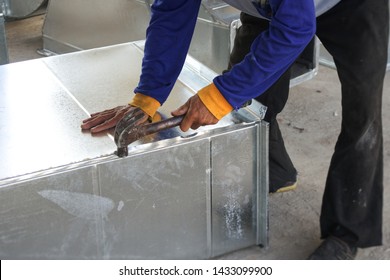 Workers Are Assembling Parts Of Air Duct Work Of Air Conditioning And Ventilation Systems.