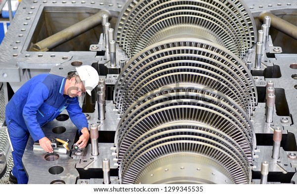 workers assembling and quality control of gas turbines\
in a modern industrial factory - checking dimensions with a\
measuring device 