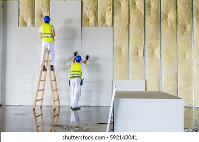 Die Arbeiter sind eine Gips-Mauer. Die Tafel wird mit einer Holzleiter gebaut.