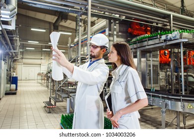 Workers of the beer factory are considering a drawing for setting up equipment. - Powered by Shutterstock