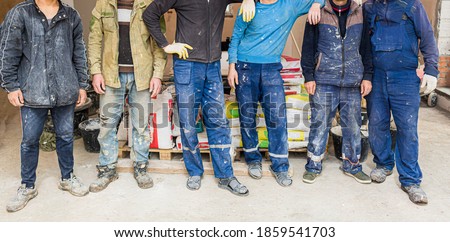 Workers and builders and foreman are as gang with dirty uniform are staying in apartment that is under construction, remodeling,renovation,extension, restoration, overhaul and reconstruction