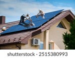 Workers building photovoltaic solar panel system on rooftop of house. Men technicians in helmets installing solar module with help of hex key outdoors. Renewable energy generation concept.