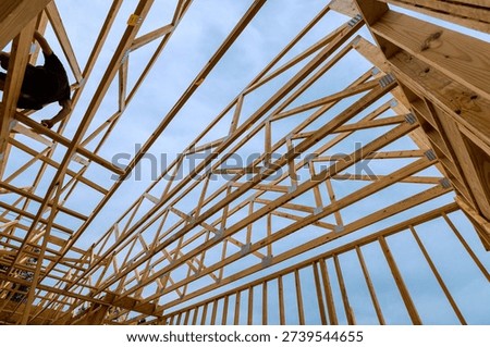 Workers are busy constructing wooden framework of building under joins beams frame