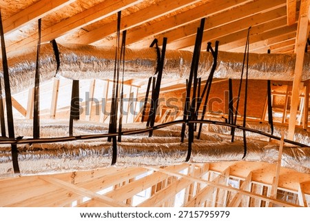 Workers are busy installing ductwork in attic ceiling of building under construction using metal plastic materials.