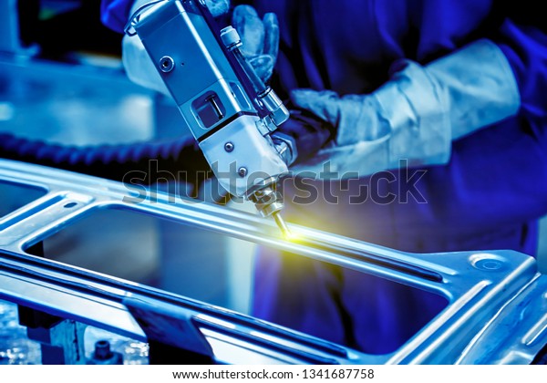 Workers in the car\
manufacturing workshop are using professional machines to glue the\
car window glass