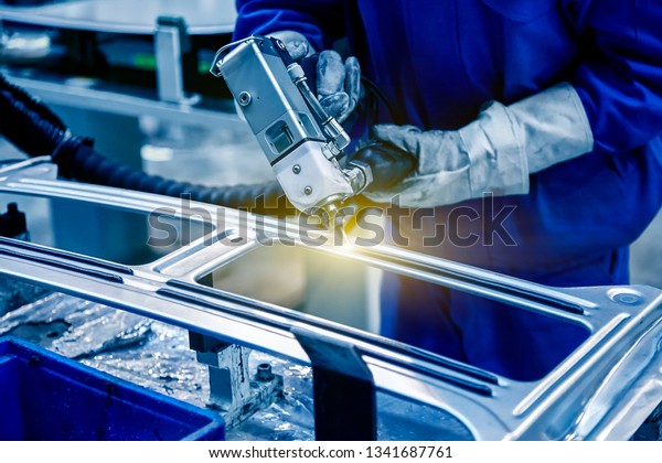 Workers in the car\
manufacturing workshop are using professional machines to glue the\
car window glass