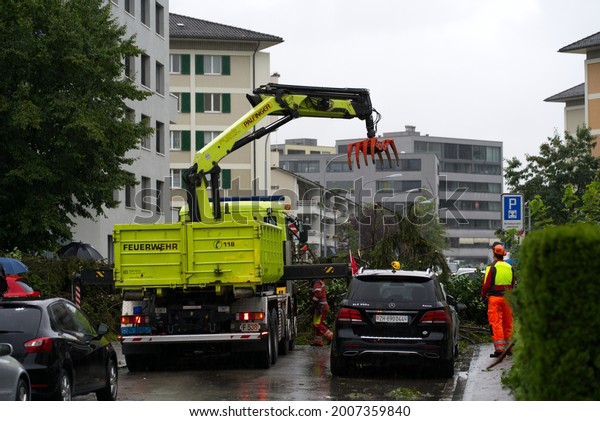 Workers cleaning roads of trees and\
branches after nightly heavy summer thunderstorm at City of Zurich.\
Photo taken July 13th, 2021, Zurich,\
Switzerland.