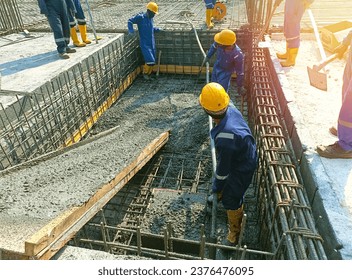 Workers concrete casting work. using concrete vibrator for compacting concrete of stiff consistency