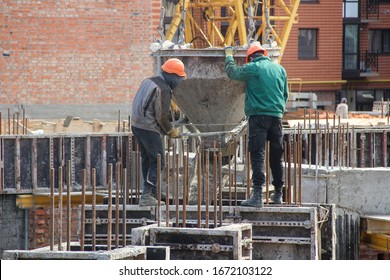 Workers At Construction Site Casting A Concrete Mixture Into The Form, Creating Demountable And Permanent Formwork