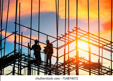 workers and construction site at sunset - Powered by Shutterstock