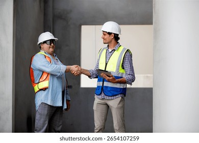 workers at construction site, young engineer manager and worker handshaking at construction site 