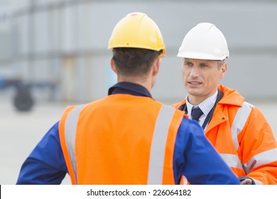 Workers conversing in shipping yard