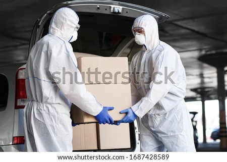 Workers in coronavirus hazmat suits delivering drugs for people because of quarantine, world pandemic