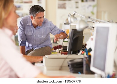 Workers At Desks In Busy Creative Office