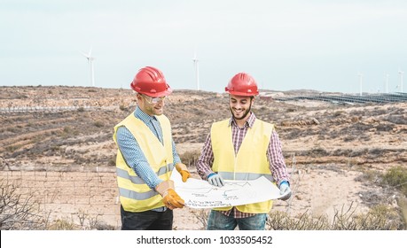 Workers engineers discussing renewable energy project - Builders planning how to build a new wind farm - Environmentally friendly, construction and saving the nature concept - Powered by Shutterstock