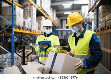 Workers With Face Mask Working Indoors In Warehouse, Coronavirus Concept.