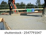 Workers filling the second floor ground with concrete, core and shell construction building 