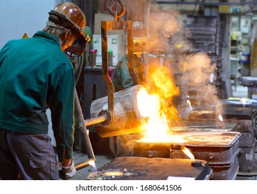 Workers In A Foundry Casting A Metal Workpiece - Safety At Work And Teamwork 