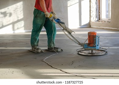 The Workers Grind The Concrete Floor At The Construction Site