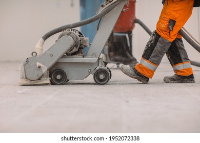 Workers Grind The Concrete Floor At The Construction Site. Prepares The Floor For Polyurethane Mortar