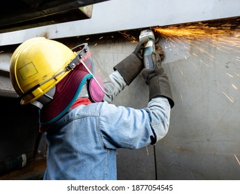 Workers are grinding and cleaning the workpiece surface to ensure quality work. - Shutterstock ID 1877054545