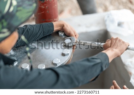 Workers hand holding machine tightening nut, The mechanic is repairing the machine in the factory, Maintenance man bolting torque in industrial plant