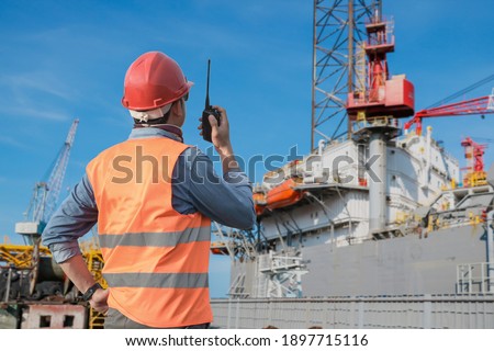 Workers hand holding walkie talkie control work in shipyard