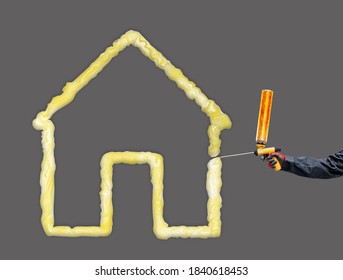 A worker's hand holds a polyurethane foam expanding glue gun and makes the house warm