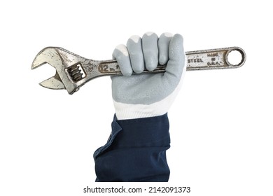A worker's hand in a protective glove and blue uniform holds a large old adjustable wrench on a white background. 