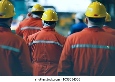 Arbeiter Helme in der Fabrik, Blick von hinten, Gruppe von Arbeitnehmern, Wechsel der Arbeiter in der Fabrik, Menschen gehen Helme und Uniformen für ein Industrieunternehmen