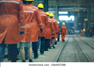 workers  helmets at the factory, view from the back, group of workers,  change of workers in the factory, people go in helmets and uniforms for an industrial enterprise