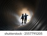 Workers inside a big steel pipe building a pipeline for oil, gas, and fuel at an industrial site.