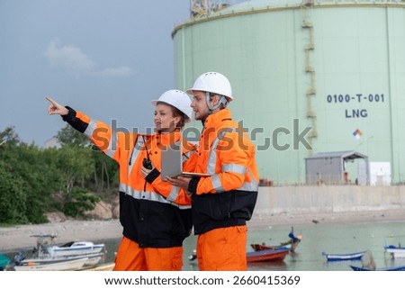 Workers inspect LNG facility while discussing safety procedures near the harbor